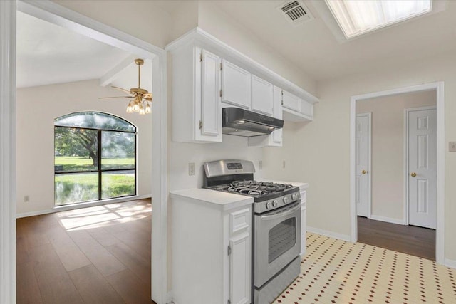 910 Garwood St, Smithville, TX 78957 - kitchen featuring stainless steel gas stove, under cabinet range hood, light countertops, white cabinetry, and dark wood-type flooring