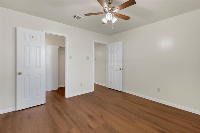 910 Garwood St, Smithville, TX 78957 - unfurnished bedroom featuring wood finished floors, a spacious closet, and a ceiling fan