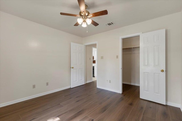 910 Garwood St, Smithville, TX 78957 - unfurnished bedroom with dark wood finished floors, a walk in closet, a closet, and ceiling fan
