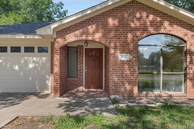 910 Garwood St, Smithville, TX 78957 - property entrance with brick siding, an attached garage, and driveway