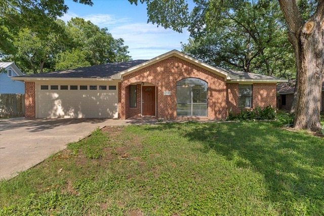 910 Garwood St, Smithville, TX 78957 - ranch-style house featuring brick siding, an attached garage, concrete driveway, and a front yard