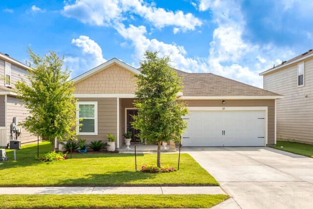 121 Rubrum Rd, Kyle, TX 78640 - view of front of house with concrete driveway, an attached garage, and a front lawn