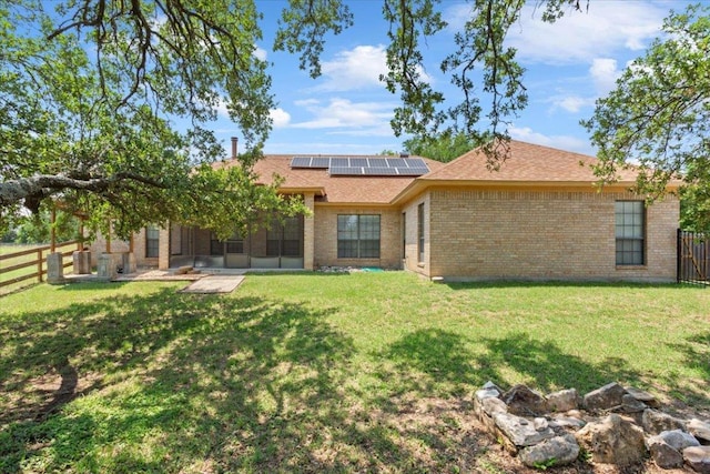 3609 Walter Ln, Belton, TX 76513 - back of house featuring a sunroom, brick siding, roof mounted solar panels, and a shingled roof