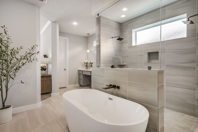 206 Bridge Water Loop, Dripping Springs, TX 78620 - bathroom featuring walk in shower, a freestanding bath, vanity, baseboards, and recessed lighting