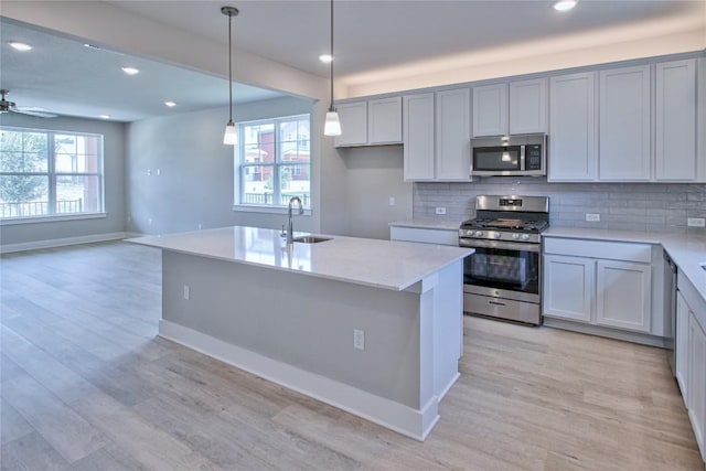 5907 Rotunda Vw, Austin, TX 78747 - kitchen featuring appliances with stainless steel finishes, a sink, decorative backsplash, light wood-type flooring, and recessed lighting