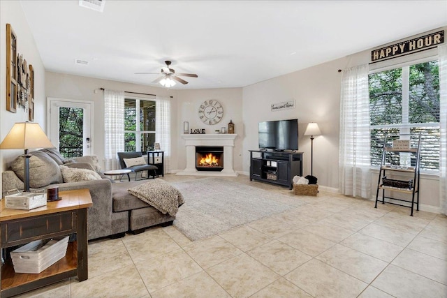 167 Limestone Trl Unit 76, Austin, TX 78737 - living area featuring ceiling fan, a warm lit fireplace, plenty of natural light, and light tile patterned floors