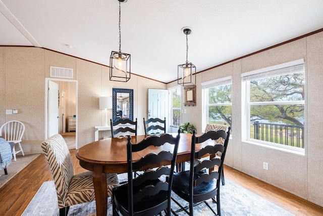 231 Wolf Run, Burnet, TX 78611 - dining room with lofted ceiling, light wood-style floors, and ornamental molding