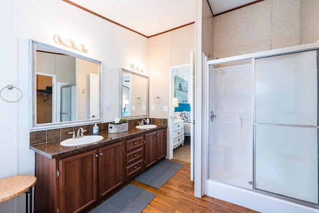 231 Wolf Run, Burnet, TX 78611 - bathroom featuring a stall shower, wood finished floors, double vanity, and crown molding