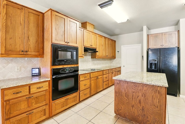 529 Honeycomb Cir, Driftwood, TX 78619 - kitchen with black appliances, under cabinet range hood, decorative backsplash, light tile patterned floors, and a center island