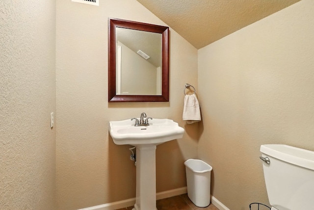 529 Honeycomb Cir, Driftwood, TX 78619 - bathroom featuring vaulted ceiling, toilet, baseboards, and a textured ceiling