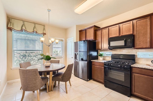 406 Epiphany Ln, Pflugerville, TX 78660 - kitchen featuring black appliances, a chandelier, light stone countertops, brown cabinets, and decorative backsplash