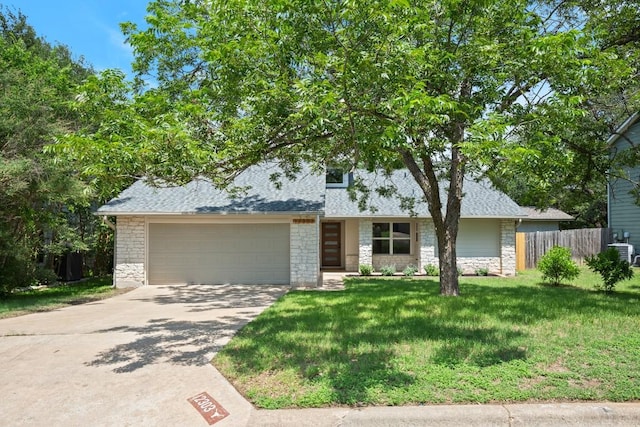 12303 Turtleback Ln, Austin, TX 78727 - view of front facade featuring stone siding, an attached garage, driveway, and a shingled roof