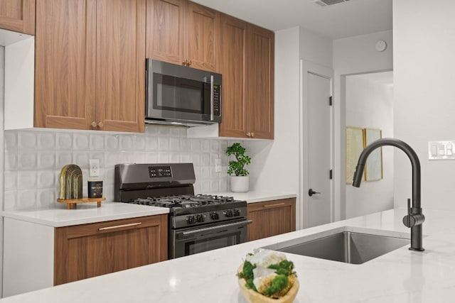 12303 Turtleback Ln, Austin, TX 78727 - kitchen with stainless steel appliances, brown cabinetry, and decorative backsplash
