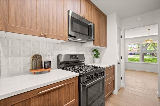 12303 Turtleback Ln, Austin, TX 78727 - kitchen with stainless steel microwave, gas range, tasteful backsplash, and light wood-style flooring