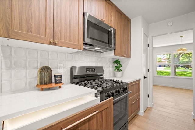 12303 Turtleback Ln, Austin, TX 78727 - kitchen featuring stainless steel microwave, gas stove, backsplash, and light countertops