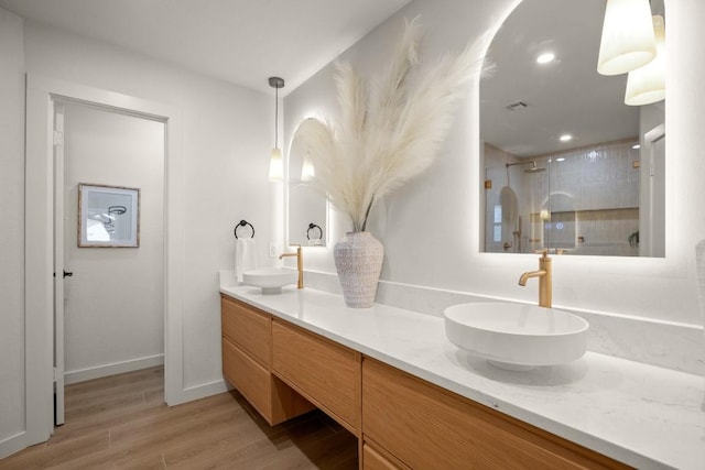 12303 Turtleback Ln, Austin, TX 78727 - bathroom featuring double vanity, wood finished floors, a shower stall, and recessed lighting