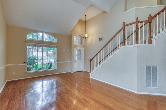 6429 Clay Allison Pass, Austin, TX 78749 - foyer entrance featuring wood finished floors, high vaulted ceiling, stairway, a chandelier, and baseboards