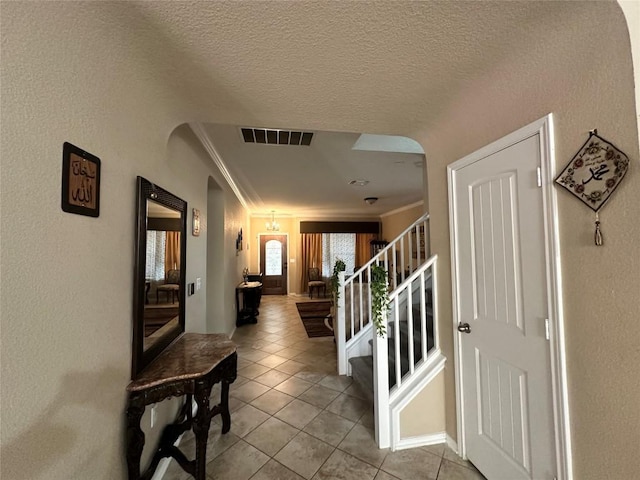 12400 Britannic Dr, Austin, TX 78753 - hallway with arched walkways, ornamental molding, light tile patterned floors, stairs, and a textured wall