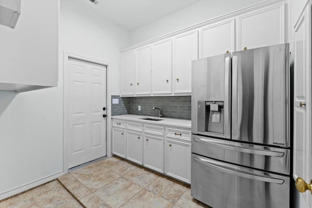 6008 Woodview Ave, Austin, TX 78757 - kitchen featuring stainless steel fridge with ice dispenser, a sink, light countertops, decorative backsplash, and white cabinets