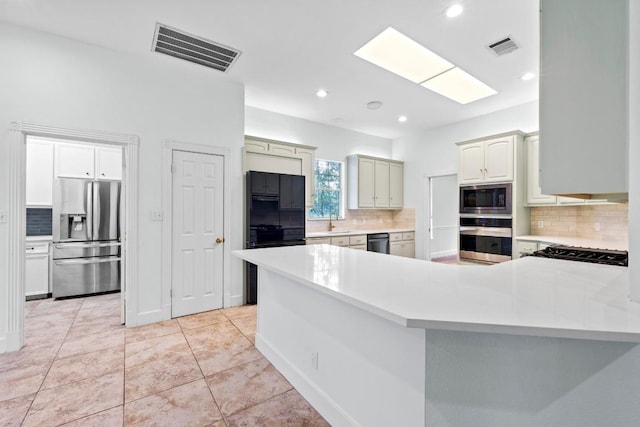6008 Woodview Ave, Austin, TX 78757 - kitchen with appliances with stainless steel finishes, backsplash, light countertops, a peninsula, and recessed lighting