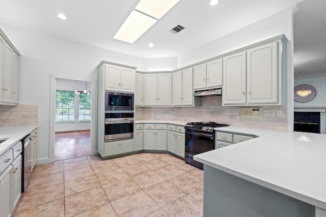 6008 Woodview Ave, Austin, TX 78757 - kitchen featuring appliances with stainless steel finishes, tasteful backsplash, light countertops, under cabinet range hood, and recessed lighting