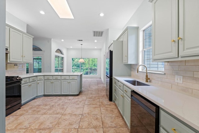 6008 Woodview Ave, Austin, TX 78757 - kitchen featuring black range with gas cooktop, dishwasher, a sink, a peninsula, and backsplash