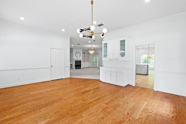 6008 Woodview Ave, Austin, TX 78757 - unfurnished living room featuring crown molding, a chandelier, recessed lighting, plenty of natural light, and light wood-type flooring