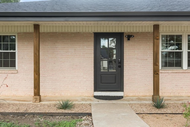 219 S Bluff St, Dripping Springs, TX 78620 - entrance to property featuring a shingled roof, brick siding, and covered porch