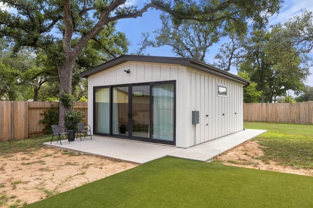 219 S Bluff St, Dripping Springs, TX 78620 - back of house featuring board and batten siding, an outbuilding, and a patio area