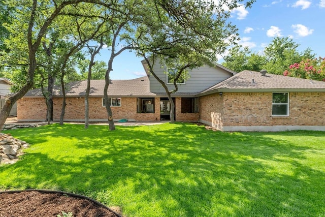801 Lime Rock Dr, Round Rock, TX 78681 - rear view of house with a yard, brick siding, and roof with shingles