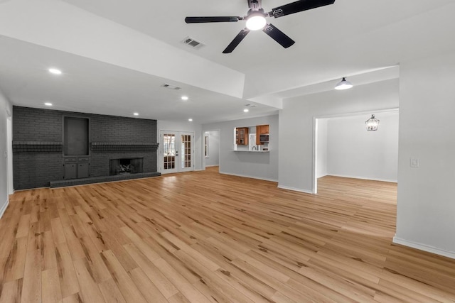 801 Lime Rock Dr, Round Rock, TX 78681 - unfurnished living room with light wood-style floors, a brick fireplace, a ceiling fan, and recessed lighting