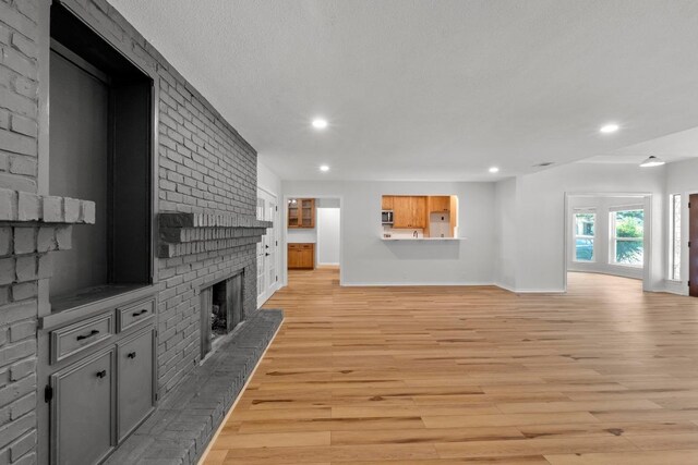801 Lime Rock Dr, Round Rock, TX 78681 - unfurnished living room featuring a brick fireplace, light wood-style flooring, and recessed lighting