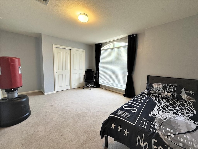 404 Autumn Trl, Georgetown, TX 78626 - bedroom with carpet flooring, a closet, a textured ceiling, and baseboards