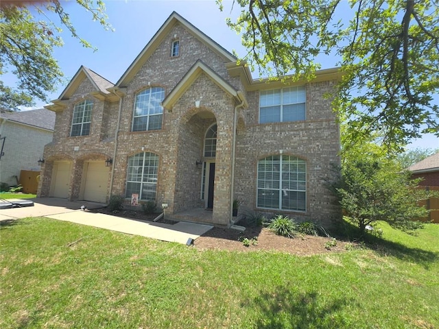 404 Autumn Trl, Georgetown, TX 78626 - traditional home with driveway, a front lawn, an attached garage, and brick siding