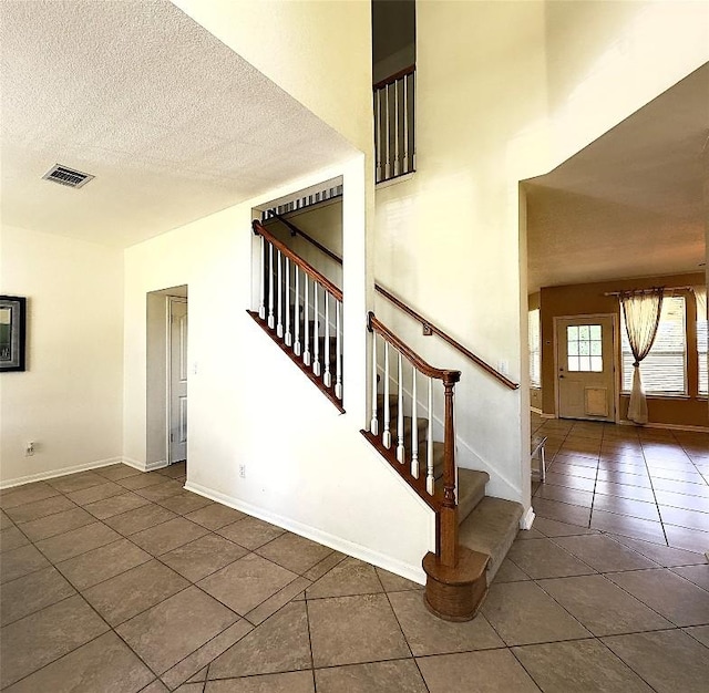 404 Autumn Trl, Georgetown, TX 78626 - stairway featuring tile patterned floors, a textured ceiling, and baseboards