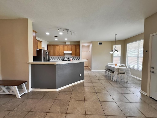 404 Autumn Trl, Georgetown, TX 78626 - kitchen featuring refrigerator with ice dispenser, under cabinet range hood, a chandelier, light tile patterned floors, and baseboards