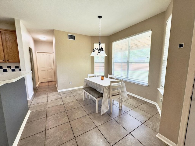 404 Autumn Trl, Georgetown, TX 78626 - dining room featuring light tile patterned flooring, baseboards, and a chandelier