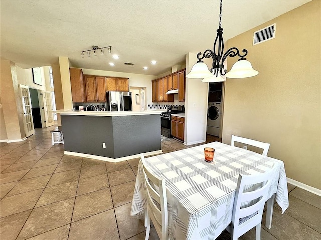 404 Autumn Trl, Georgetown, TX 78626 - dining area featuring washer / dryer, a chandelier, light tile patterned flooring, baseboards, and a textured ceiling