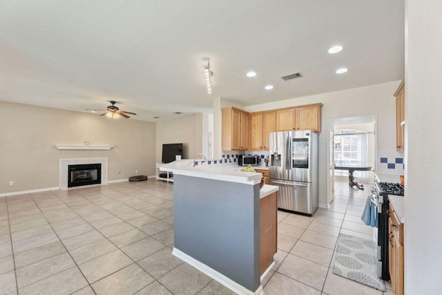 404 Autumn Trl, Georgetown, TX 78626 - kitchen featuring stainless steel appliances, light tile patterned flooring, light countertops, a peninsula, and recessed lighting