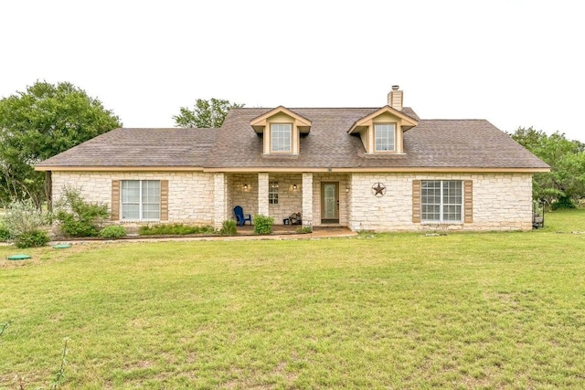518 Clear Creek Ln, Dripping Springs, TX 78620 - new england style home featuring a chimney, stone siding, a front yard, and roof with shingles