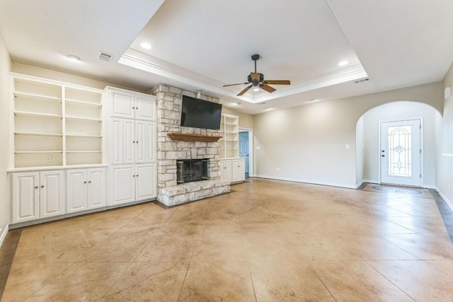 518 Clear Creek Ln, Dripping Springs, TX 78620 - unfurnished living room with ceiling fan, arched walkways, a tray ceiling, baseboards, and recessed lighting