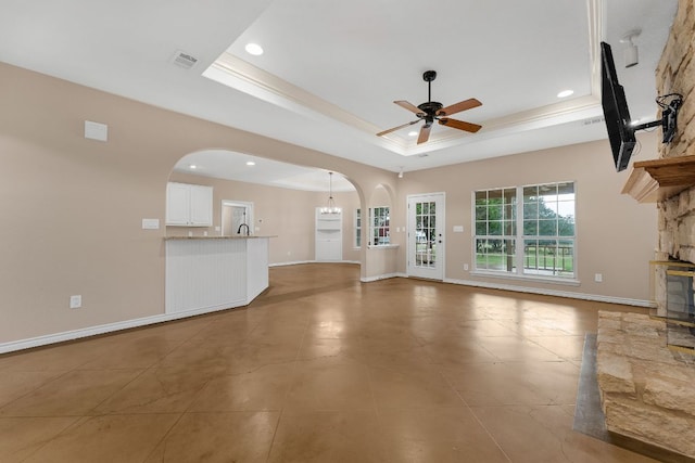 518 Clear Creek Ln, Dripping Springs, TX 78620 - unfurnished living room featuring arched walkways, a ceiling fan, recessed lighting, a tray ceiling, and baseboards