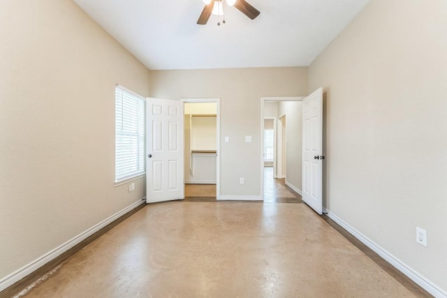 518 Clear Creek Ln, Dripping Springs, TX 78620 - unfurnished bedroom featuring finished concrete floors, multiple windows, a spacious closet, and baseboards
