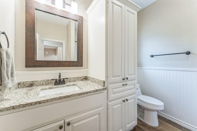 518 Clear Creek Ln, Dripping Springs, TX 78620 - bathroom featuring toilet, a wainscoted wall, and vanity