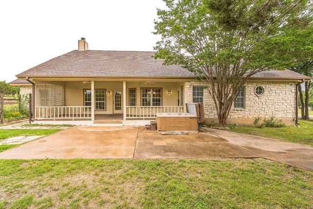 518 Clear Creek Ln, Dripping Springs, TX 78620 - rear view of house with a hot tub, a chimney, a lawn, a patio area, and stone siding