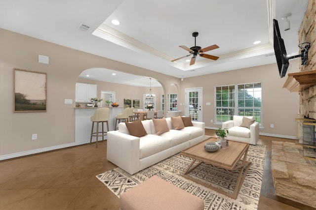 518 Clear Creek Ln, Dripping Springs, TX 78620 - tiled living room featuring arched walkways, recessed lighting, a tray ceiling, a ceiling fan, and baseboards