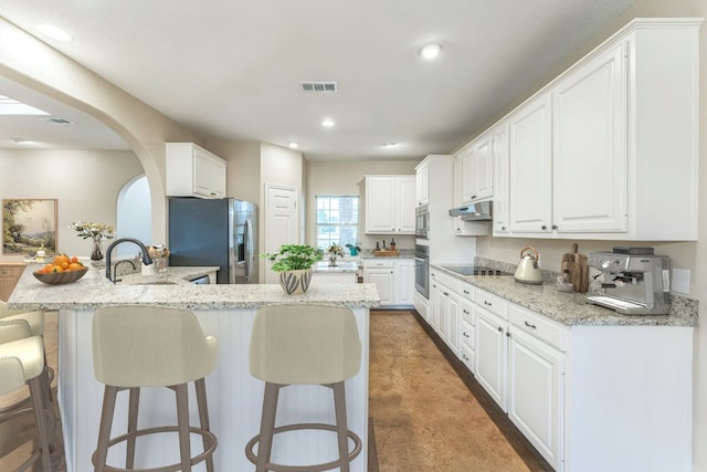 518 Clear Creek Ln, Dripping Springs, TX 78620 - kitchen featuring a kitchen bar, stainless steel appliances, a peninsula, white cabinets, and recessed lighting