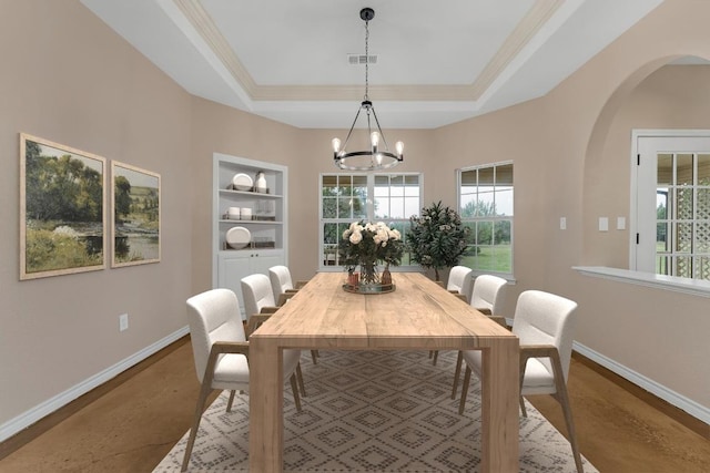 518 Clear Creek Ln, Dripping Springs, TX 78620 - dining area featuring baseboards, arched walkways, a chandelier, a tray ceiling, and built in shelves