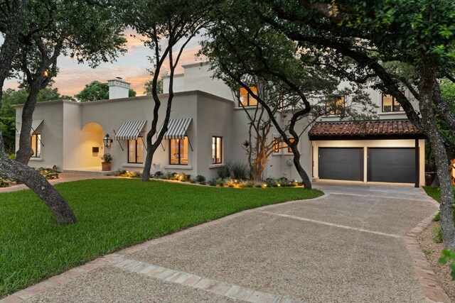 4622 Lake View Dr, Austin, TX 78731 - view of front of house with stucco siding, a front yard, a chimney, driveway, and a garage