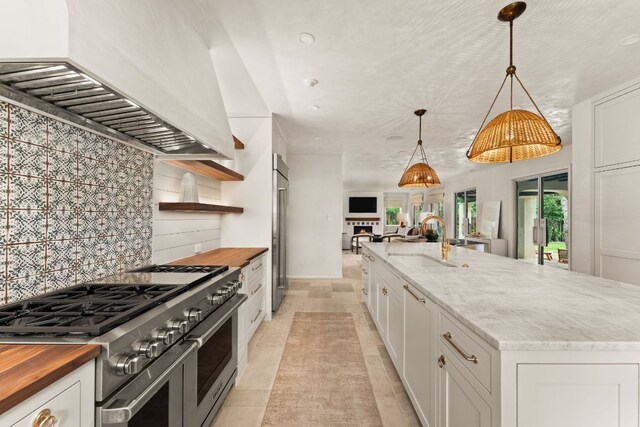 4622 Lake View Dr, Austin, TX 78731 - kitchen with premium appliances, custom exhaust hood, butcher block counters, a sink, and open floor plan